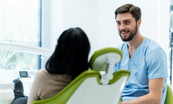 Dentiste qui parle à sa patiente (de dos)