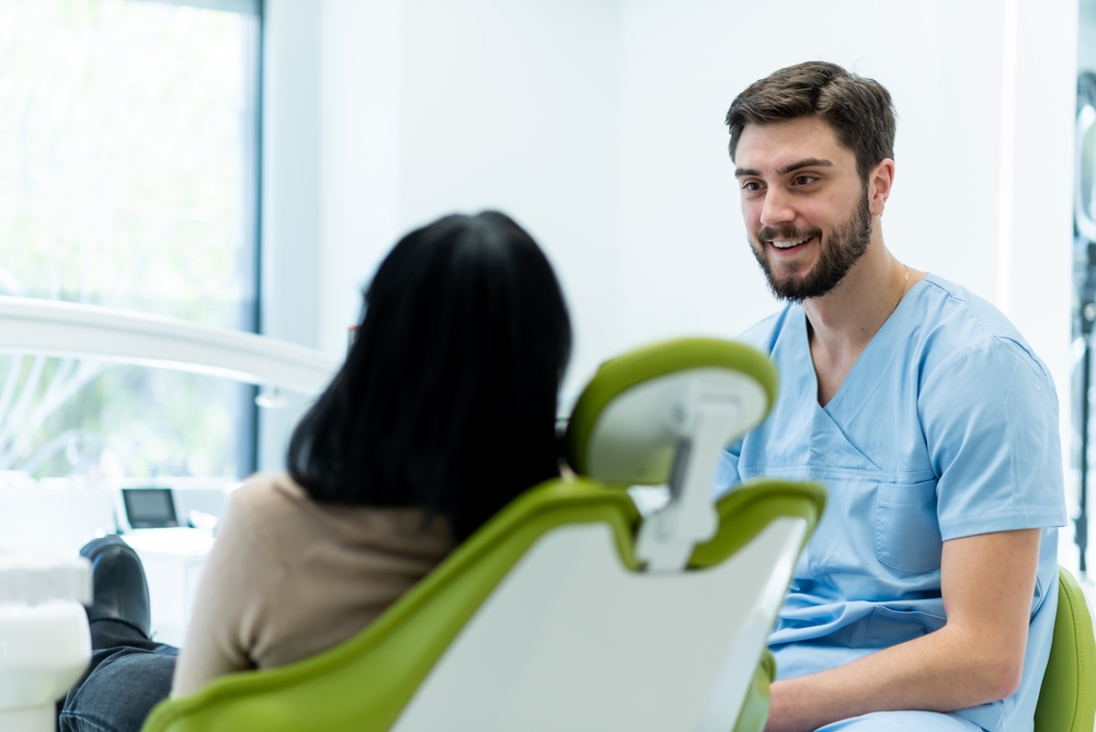 Dentiste qui parle à sa patiente (de dos)
